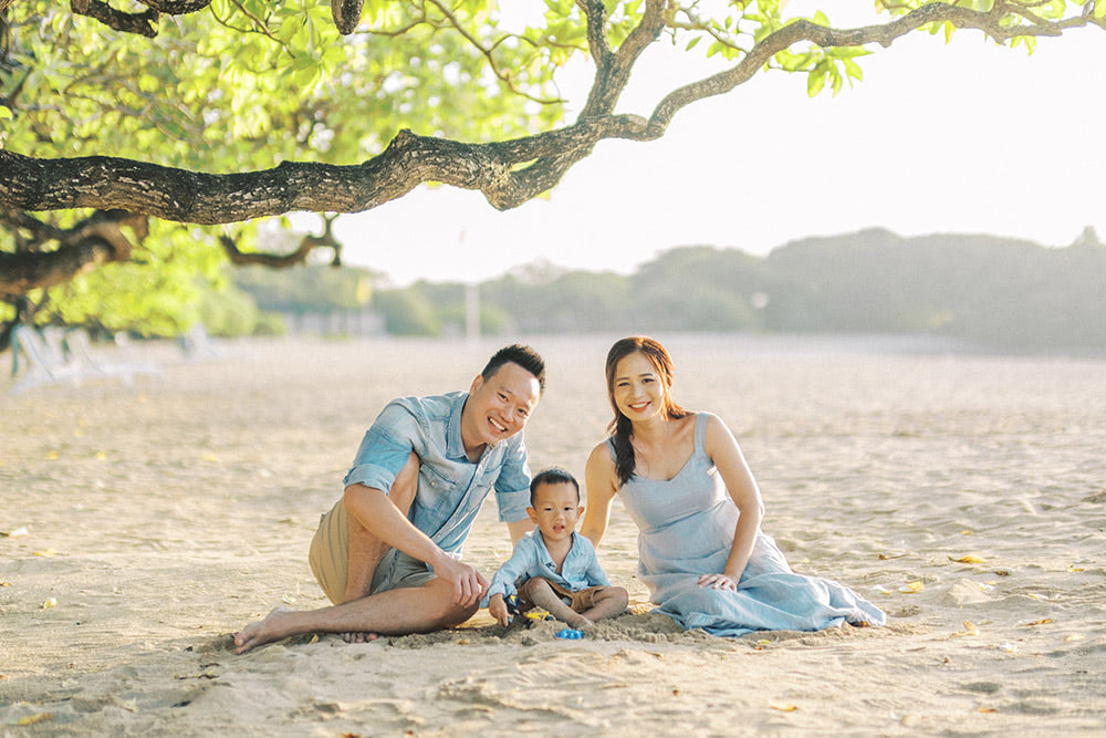 A family sitting on a beach in Bali