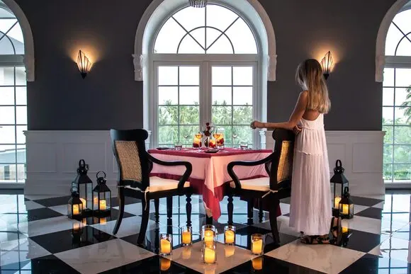 A woman standing next to a candlelit table at Apéritif Restaurant in Ubud